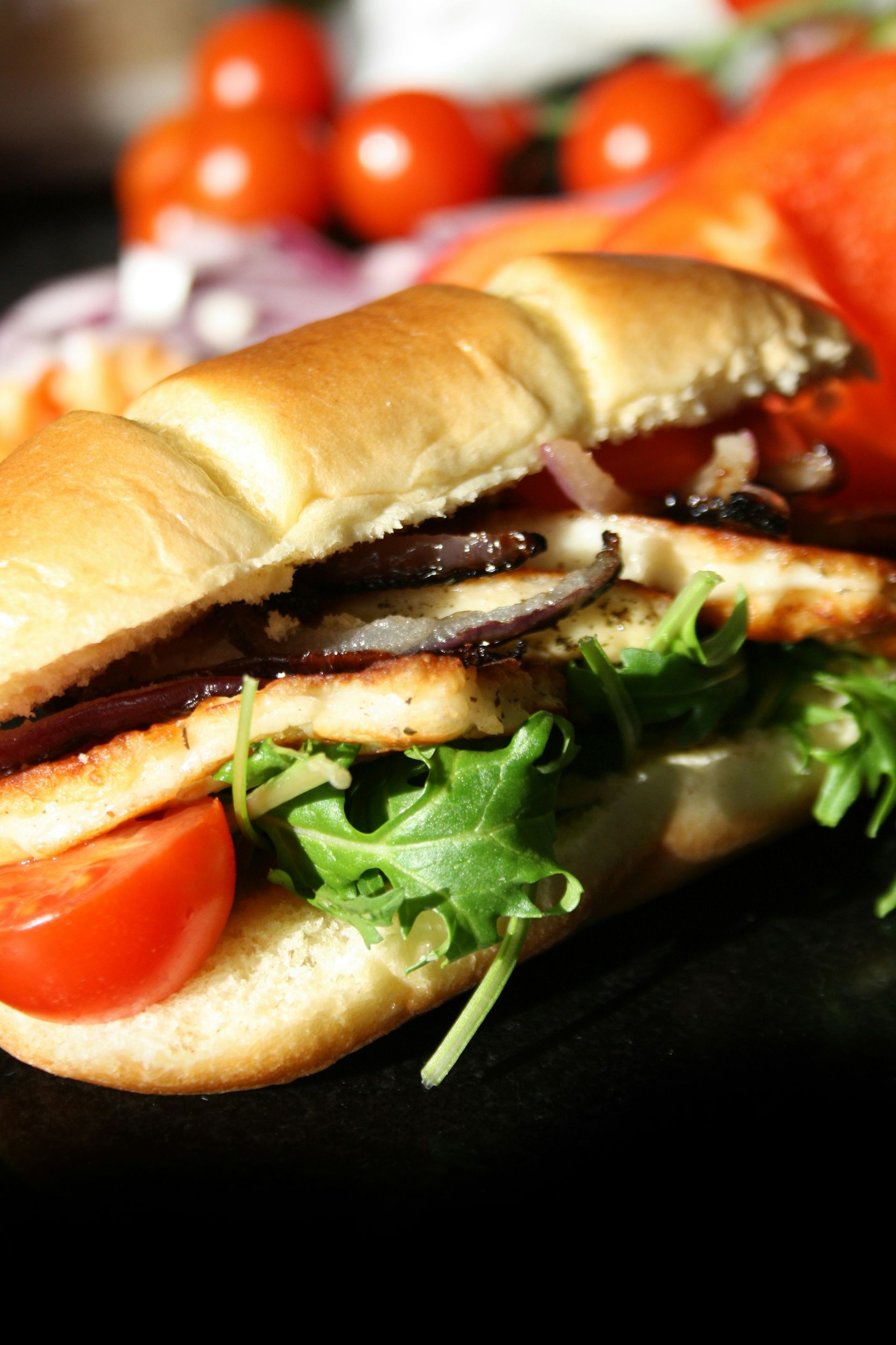 A close up of a sandwich with tomatoes and lettuce